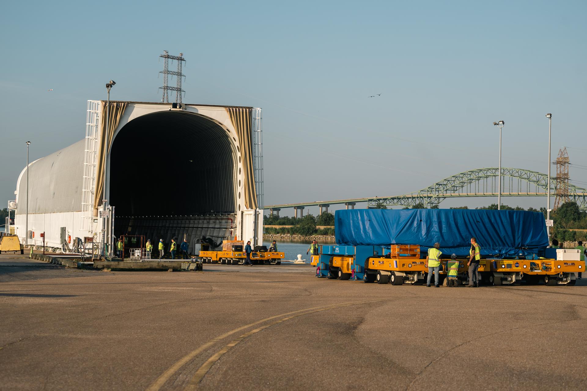 The Artemis IV core stage’s boat tail section is lifted and moved from its production area at NASA’s Michoud Assembly Facility in New Orleans on Aug. 24, 2026. The boat tail refers to the aerodynamic portion positioned directly above the exposed RS-25 engine nozzles, which comprise the lower portions of the core stage’s engine section. The boat tail critically shields the rocket’s lowermost hardware, including the engines’ upper components, plumbing, and critical control systems, protecting them from the extreme heat, vibrations, and pressures during launch. The completed hardware is lifted via the factory’s overhead crane system and secured onto two self-propelled modular transporters—NASA’s mobile heavy transport platforms,—for a short, low-speed drive across the facility, from the factory to the Pegasus barge. From New Orleans, the hardware travels to Kennedy Space Center for future engine section integration, and eventual stacking following the Artemis III mission. Through the Artemis campaign, NASA will send astronauts to explore the Moon for scientific discovery, economic benefits, and to build the foundation for the first crewed missions to Mars—for the benefit of all.